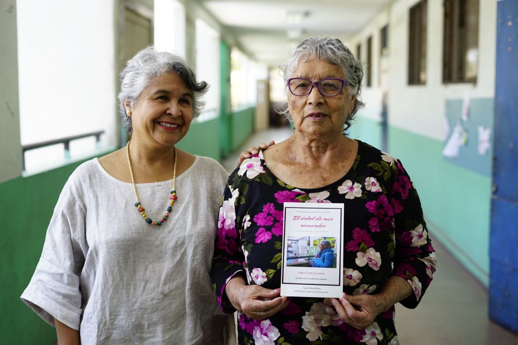 “No hay edad para aprender y menos para escribir, las personas mayores tenemos mucho que decir” Sin saber leer ni escribir, a sus 80 años Cruz Delgado decidió retomar sus estudios de enseñanza básica. Con una emergencia sanitaria de por medio, debido al coronavirus, este 2022, con 87 años finalizó su enseñanza media y publicó su primer libro. Tras una infancia y adolescencia en el campo, se dedicó a trabajar la mayor parte de su vida, posponiendo su formación académica formal. Cruz Delgado (87) nació en mayo de 1935 en un pueblo al interior de Ovalle. A los 25 años decidió migrar a la ciudad, pasando primero por Coquimbo, luego por Arica, para finalmente asentarse en Cerro Navia, Santiago. Es viuda, madre, abuela y bisabuela, y sus memorias quedaron plasmadas a través de distintos géneros literarios en la publicación que corresponde a su primer libro. “El Árbol de mis Recuerdos es completamente personal, mezcla historias de mi vida con la fantasía, con la poesía, e incluso la carta”, describe Cruz. Este libro nace en medio de un proceso de duelo, y en pandemia. Escrito a mano, fue traspasado a digital por Elena Salgado, profesora de Lengua Castellana y Comunicación del Centro Integrado de Adultos Georgina Salas Dinamarca, donde estudió Cuz. Además, tuvo la colaboración de ediciones Caballo de Mar en la impresión. “Trabajar con personas mayores, y con adultos en general, es una experiencia enriquecedora. Conoces a personas que por distintas circunstancias quedaron excluidos y no pudieron completar sus estudios. Esas personas deben saber que no han fracasado, que cualquier edad es buena para continuar con la enseñanza, siempre hay más posibilidades” expresó Elena. Con el apoyo del establecimiento, Cruz y Elena se encuentran trabajando en el segundo libro de la autora, y además en el Concurso Literario Cruz Delgado, enfocado en personas con interés en la escritura que se encuentren cursando una nivelación de estudios, para poner en valor que el talento en la escritura no tiene edad.
